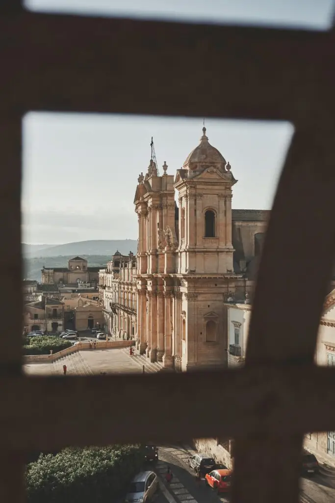 Beautiful baroque architecture of Noto Cathedral in Sicily, Italy, viewed through a window frame.