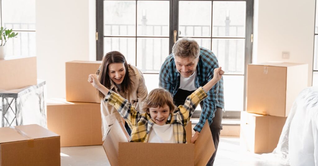 Happy family celebrating move into new home with unpacked boxes.
